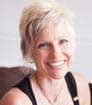 Head shot of smiling author AJG with cropped blonde hair